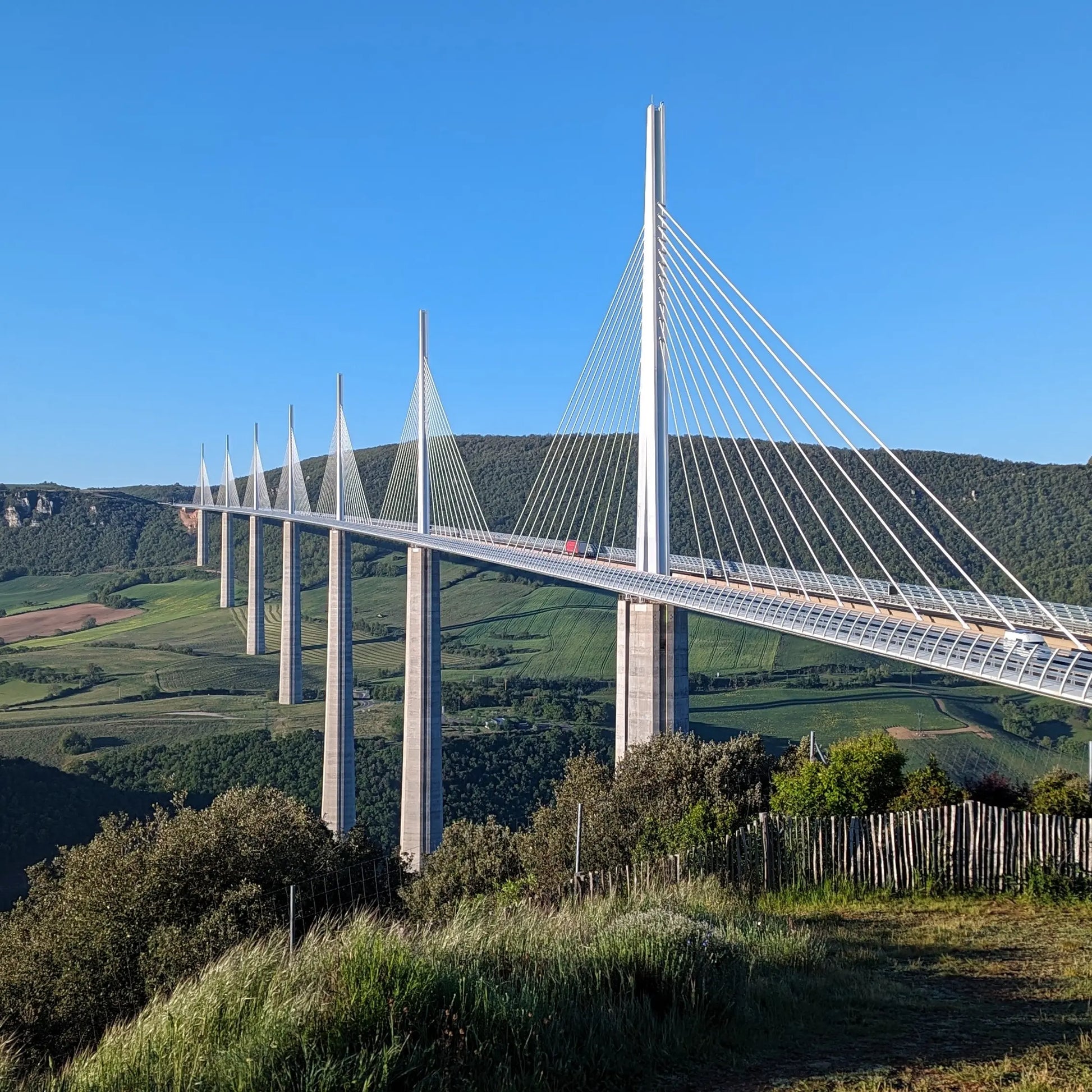The Millau Viaduct bridge spanning the Tarn Valley in France, showcasing its iconic cable-stayed design from the official hilltop viewing point.