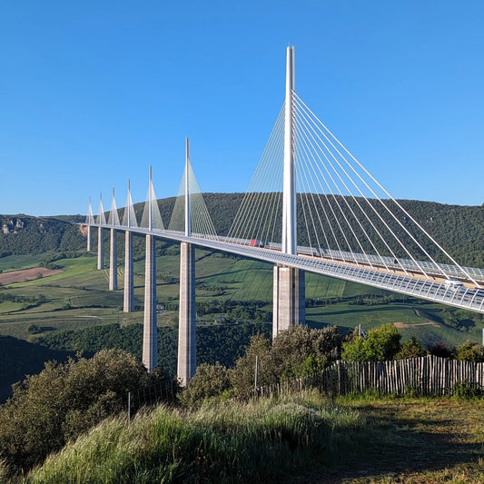 The Millau Viaduct bridge spanning the Tarn Valley in France, showcasing its iconic cable-stayed design from the official hilltop viewing point.